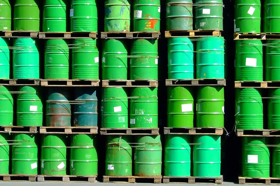 pallets of green oil barrels stacked